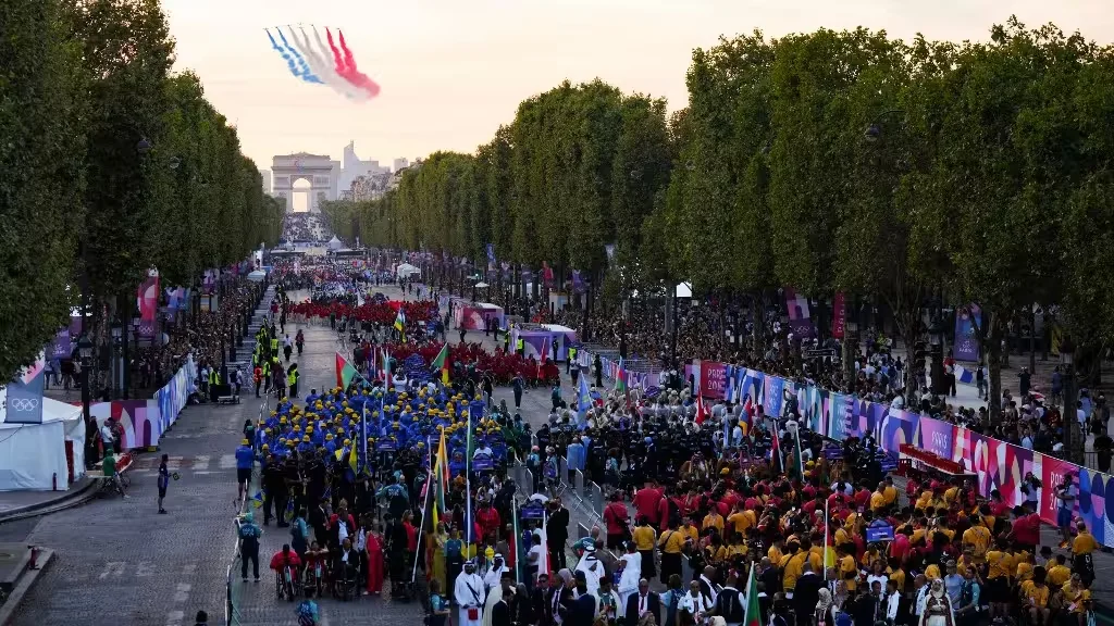 Défilé sur une grande avenue parisienne, fumées tricolores dans le ciel