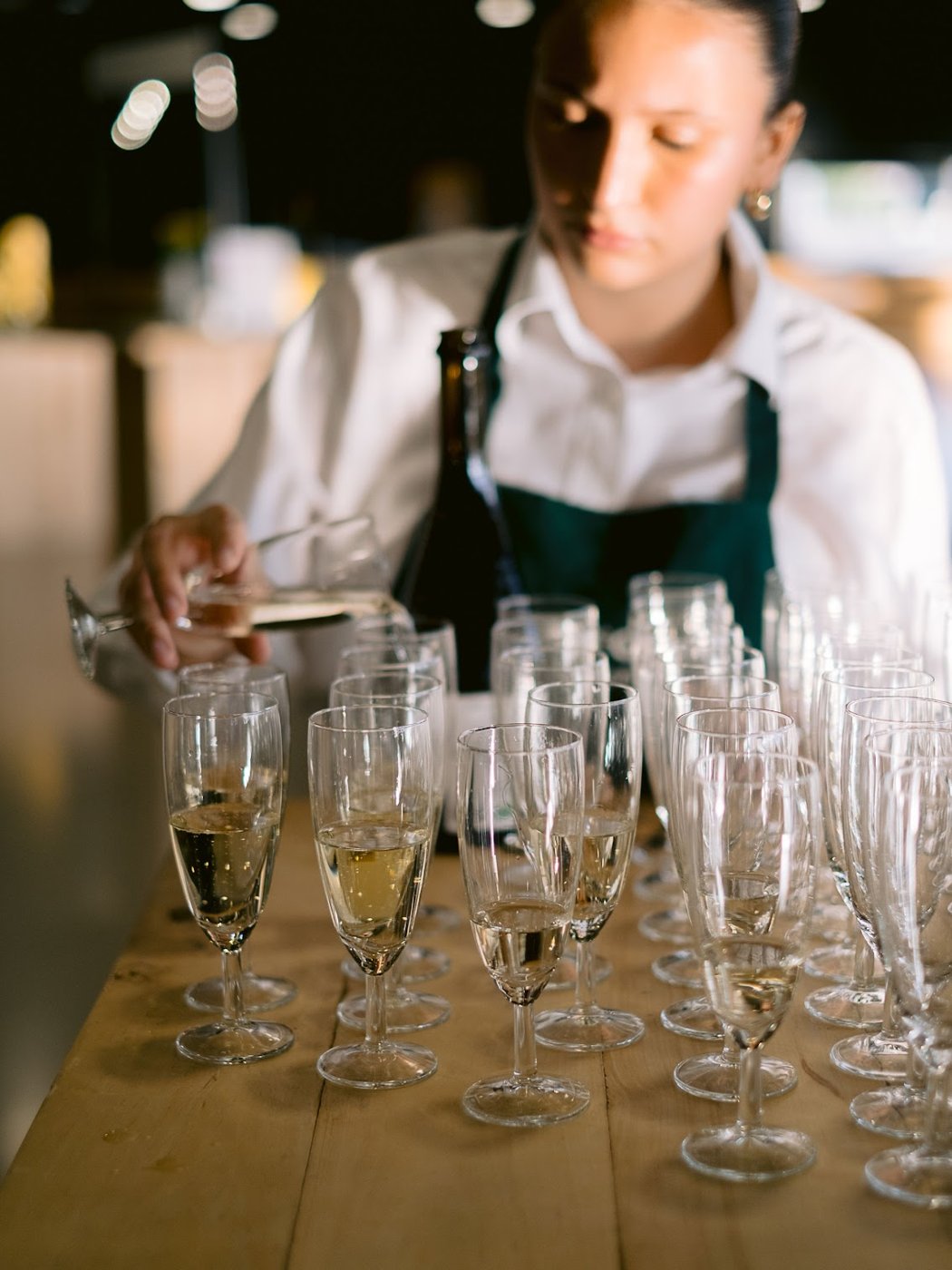 Une serveuse remplit des coupes de champagne