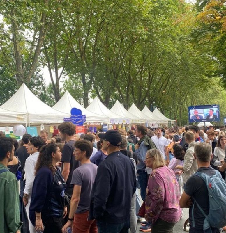 Tentes blanches et public sous les arbres des Champs-Élysées