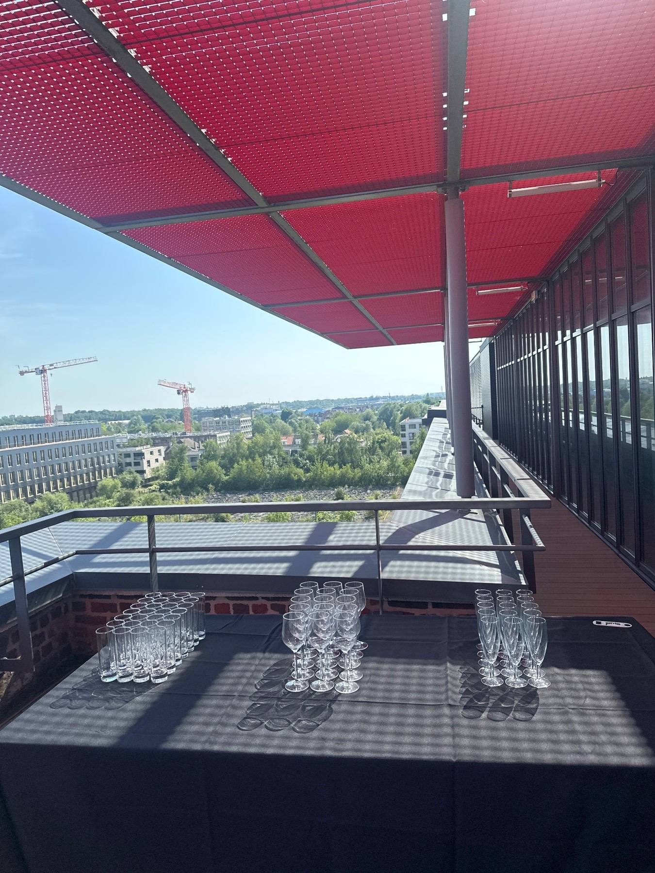 Verres dressés sur la terrasse en étage d'EuraTechnologies, sous l'auvent rouge