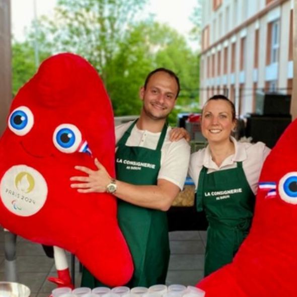 Deux membres de l'équipe avec les mascottes de Paris 2024